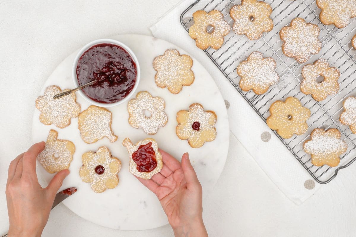 Overhead view of a woman's hands, decorating shortbread cookies for food business ideas from home