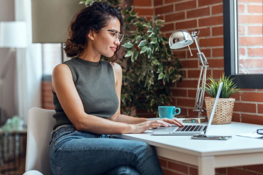 Content creator working from home at a desk and looking out a window.