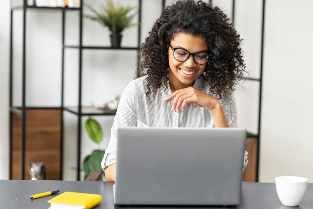 A woman working from home office at a desk and laptop.