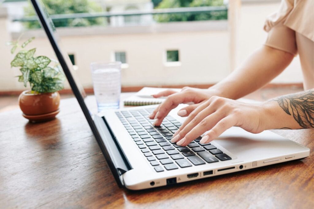 A woman working from her home office desk, using a laptop.
