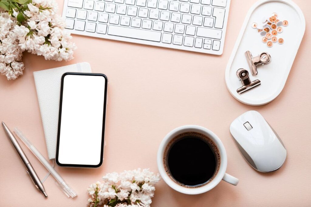 Overhead image of wedding flowers and accessories on remote worker's desk.