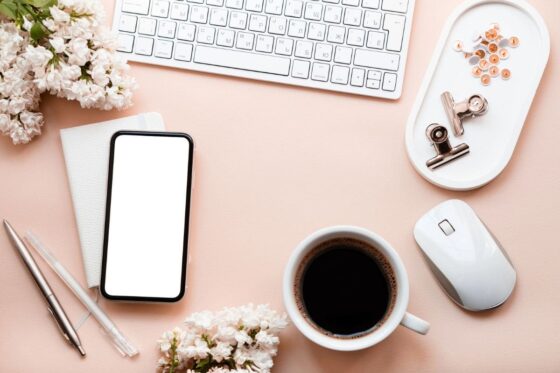 Overhead image of wedding flowers and accessories on a remote worker's desk.
