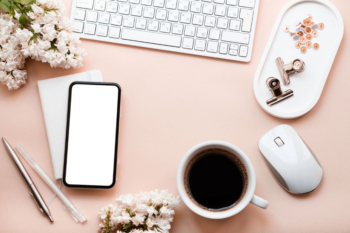 Overhead image of wedding flowers and accessories on a remote worker's desk.