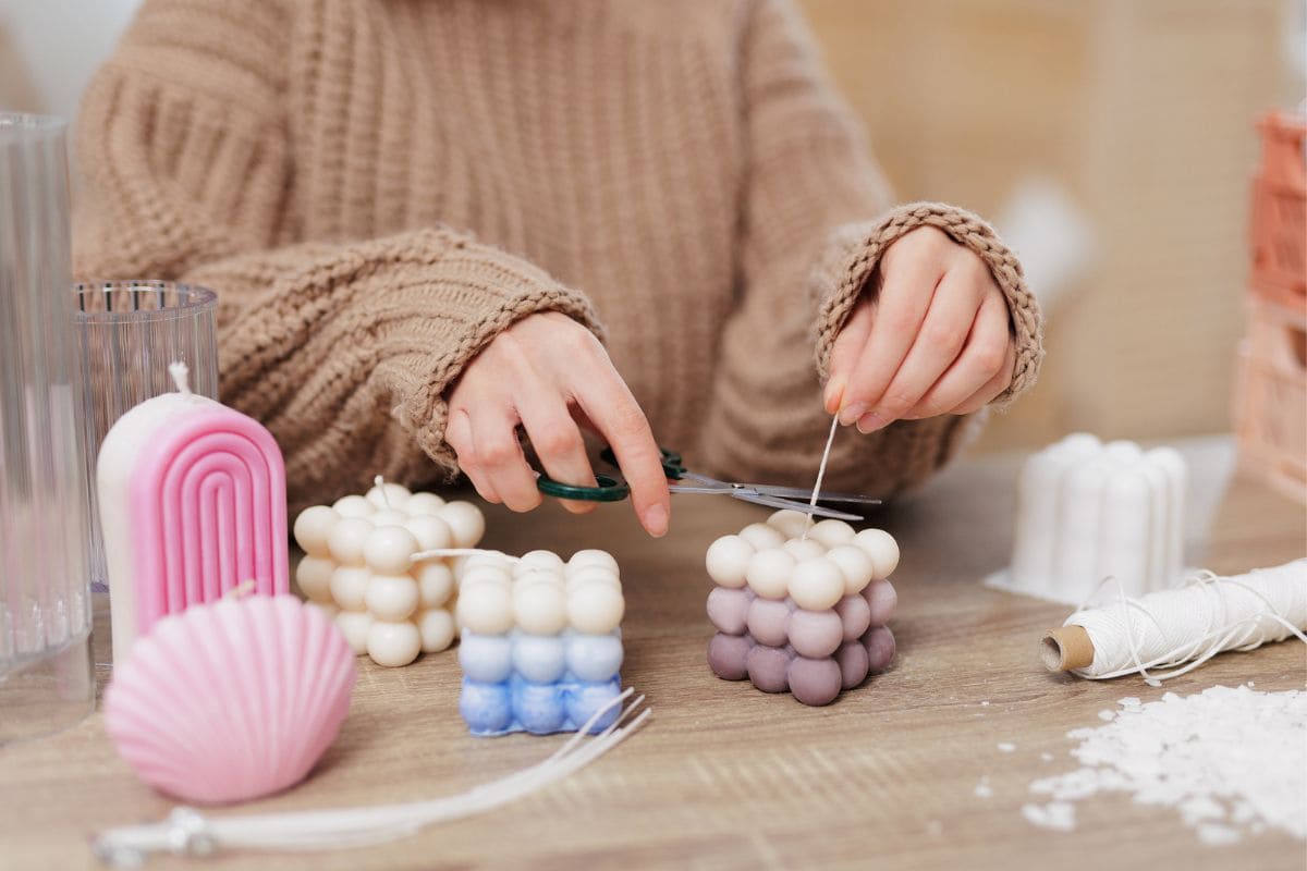 Closeup of a woman creating handmade candles to make and sell from home.