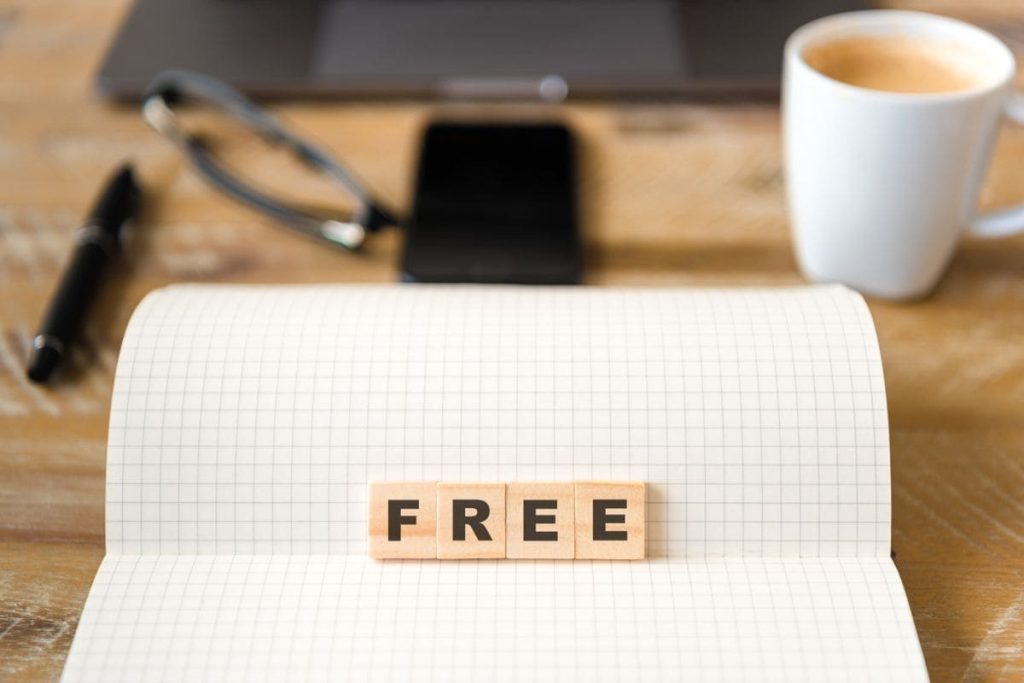 The word "free" spelled out with wooden blocks on a computer desk.