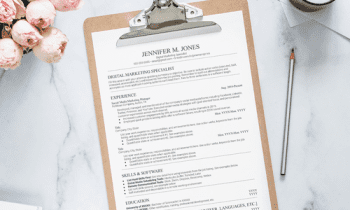Clipboard with resume template sitting next to a vase of flowers