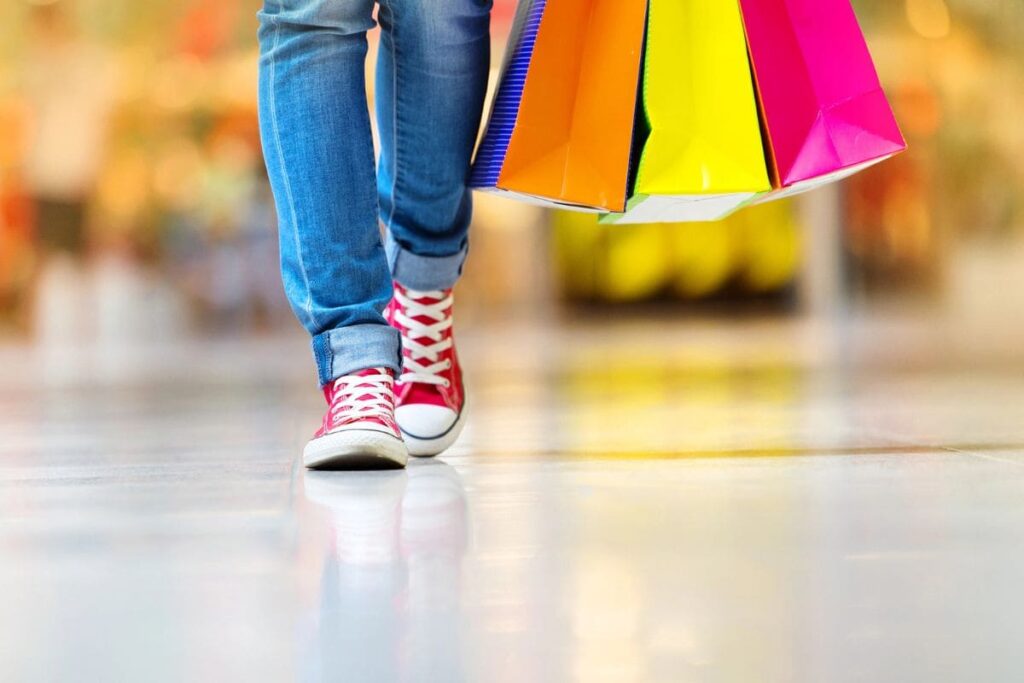 A closeup of a woman holding shopping bags while walking in the mall.