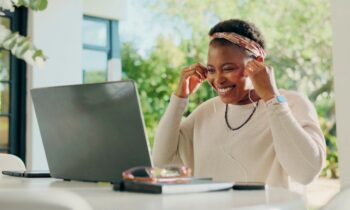 A woman working remotely from an outdoor table, putting on earphone to take a virtual call for blog post unique jobs from home
