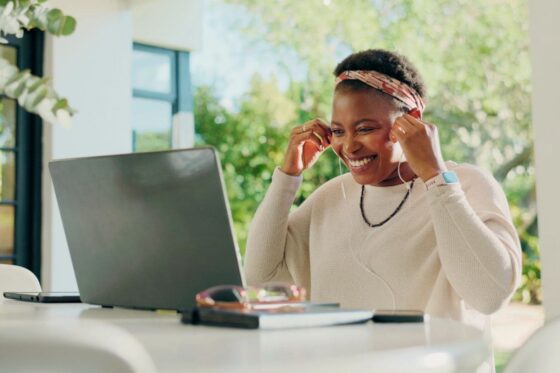 A woman working remotely from an outdoor table, putting on earphone to take a virtual call for blog post unique jobs from home