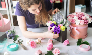 A female crafter putting together fake flower arrangements for the blog post home assembly jobs