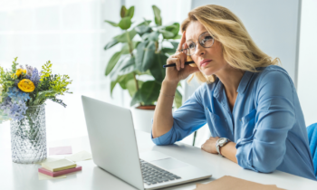 A middle aged woman sitting at her desk looking for remote companies that hire older workers