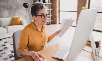 A middle aged woman working on her laptop at home conducting online research for clients
