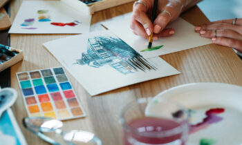 A woman in her art studio painting a picture to sell online for blog post fun ways to make money