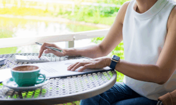 A woman sitting outdoors adding to-dos to her notebook for blog post running errands for money