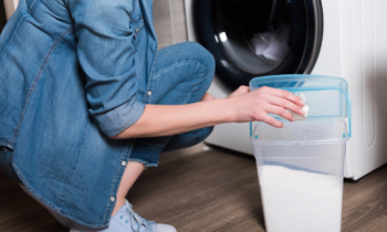 A woman wearing blue jeans working from home getting paid to do laundry