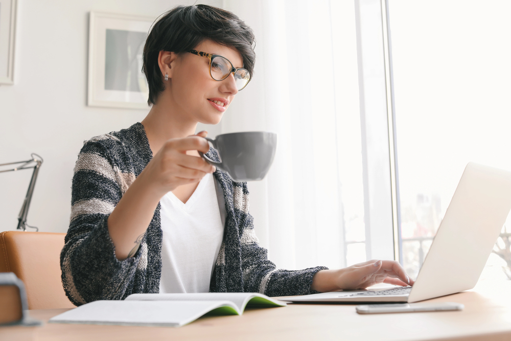A woman wearing glasses searching for a work from home job with an A rating with the BBB