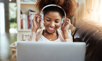 A woman who is getting paid to listen to music on her laptop