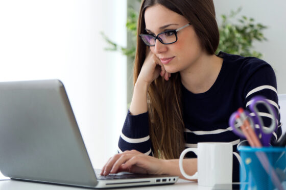 A woman with long brown hair wearing glasses participating in a paid focus group online