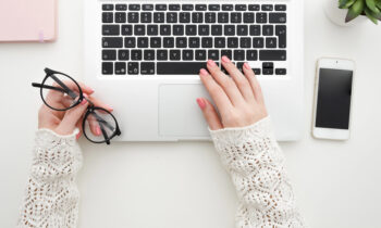 A woman with painted finger nails searching for online typing jobs on her laptop
