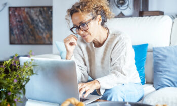A woman working on her laptop reading an article titled the best remote jobs for introverts