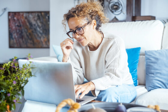 A woman working on her laptop reading an article titled the best remote jobs for introverts