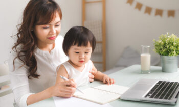 A young mother and daughter sitting at desk for blog post jobs to do during school hours