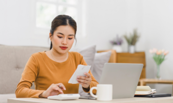 A young woman calcuting her income and expenses for blog post how to make $10K a month