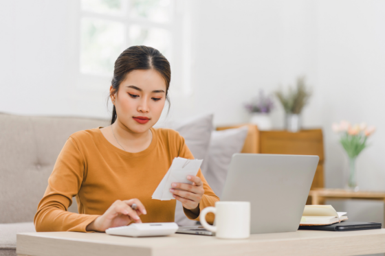A young woman calcuting her income and expenses for blog post how to make $10K a month