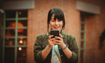 A young woman looking at her mobile device learning about mobile phone jobs