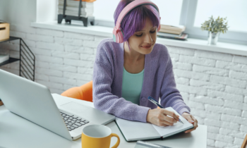 A young woman with purple hair wearing headphone is researching ways to start a business with no money