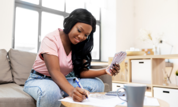 African American woman counting money at home for blog post odd ways to make money