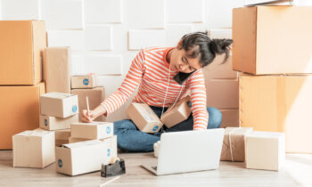 An Amazon entrepreneur boxing packages up from home for Amazon work at home jobs blog post