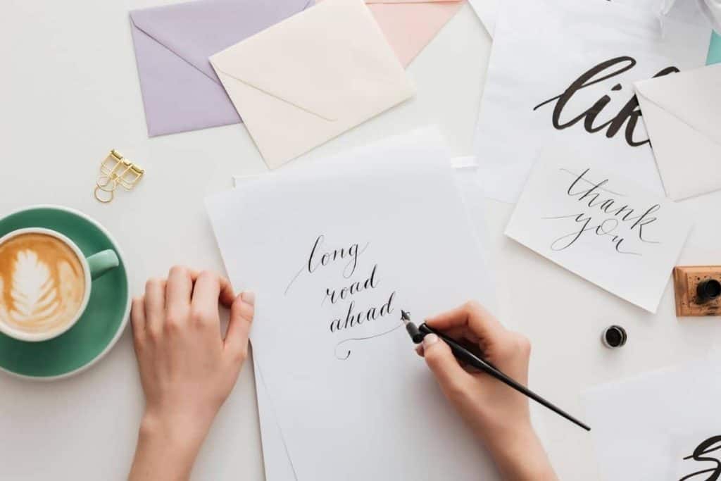 Woman handwriting calligraphy on stationary at home