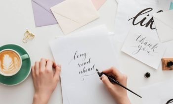 Woman handwriting calligraphy on stationary at home