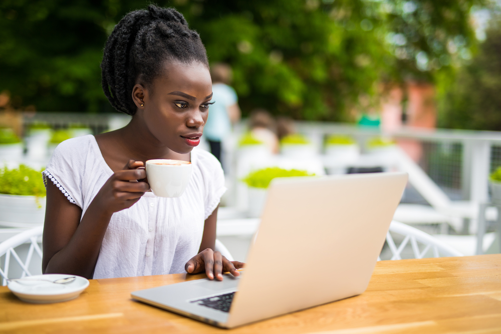 Black woman drinking coffee participating in a paid focus group online