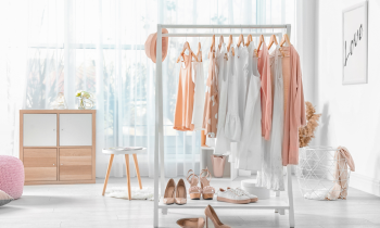 clothing rack in a bedroom sitting next to shoes