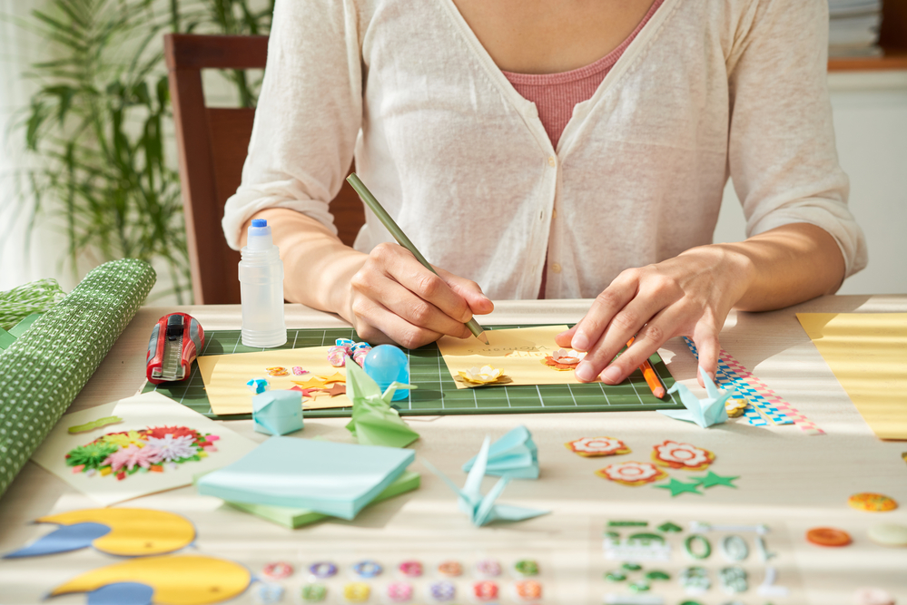 Woman sitting at a table creating one-of-kind greeting cards