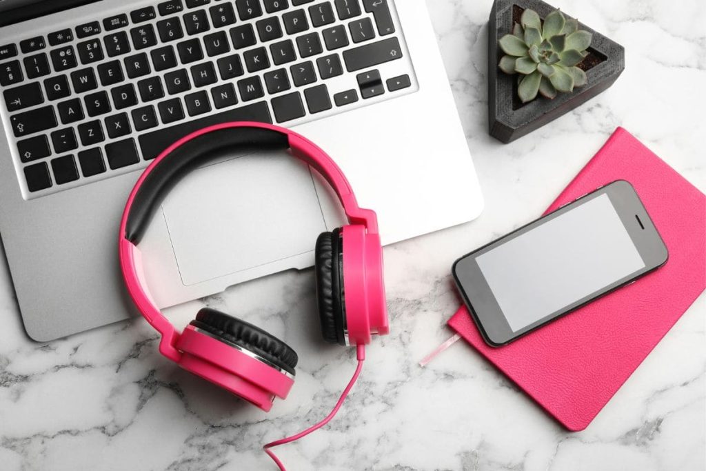 A work-from-home copying desk with a laptop, headphones and a notebook