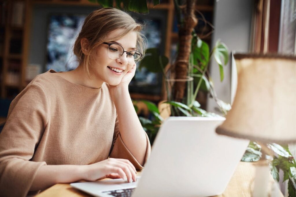 A woman working from her home office desk, using a computer.