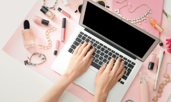 Female business owner working on laptop for her online retail makeup and jewelry business