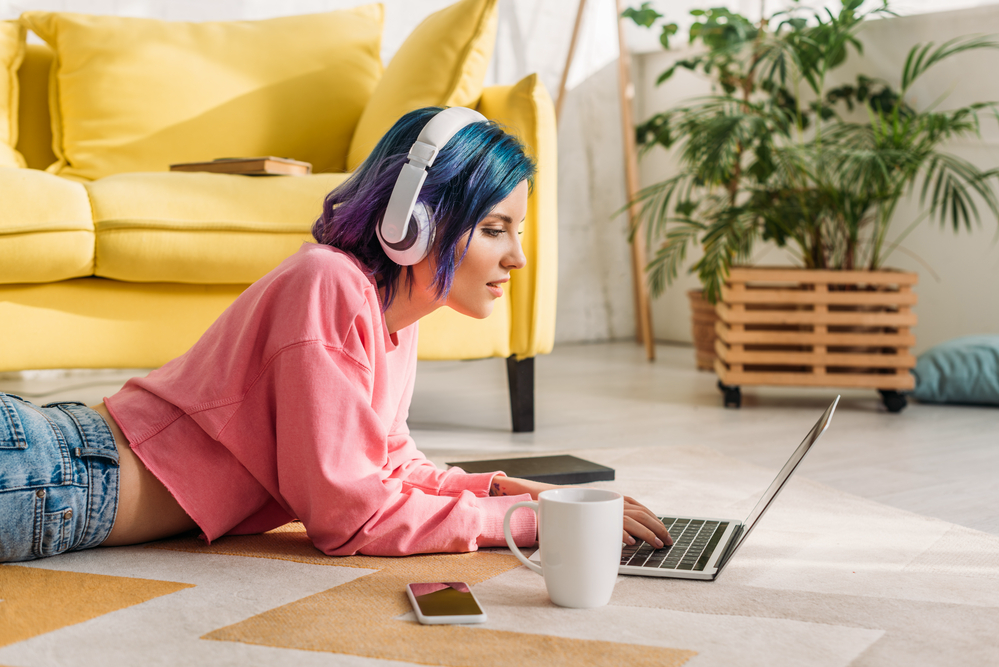 Female freelancer working her virtual jobs listening to music on her headphones while typing