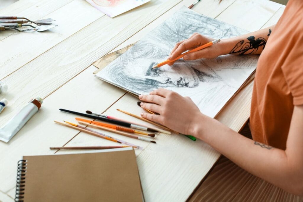 Closeup image of an artist drawing in a sketchbook.