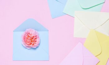 An assortment of greeting cards and envelopes on a flat background for the blog post get paid to write greeting cards from home