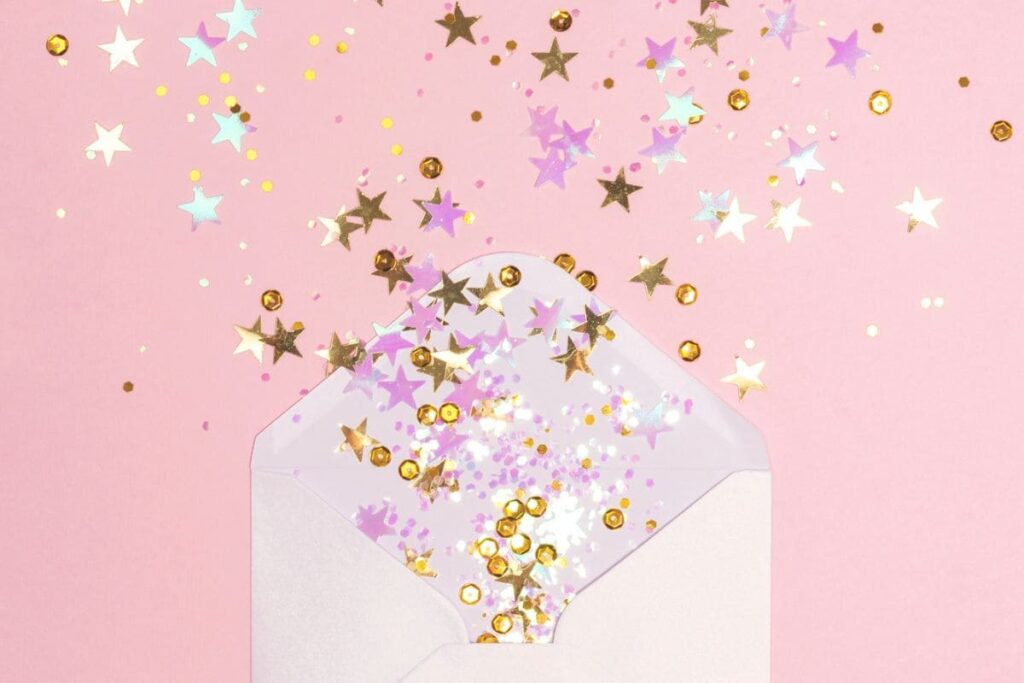 A greeting card envelope with confetti spilling out of it.