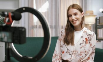 An influencer filming Walmart affiliate content from home, sitting on a couch, using a ring light.