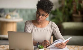 A remote worker, using a laptop and working from home as a freelance writer.