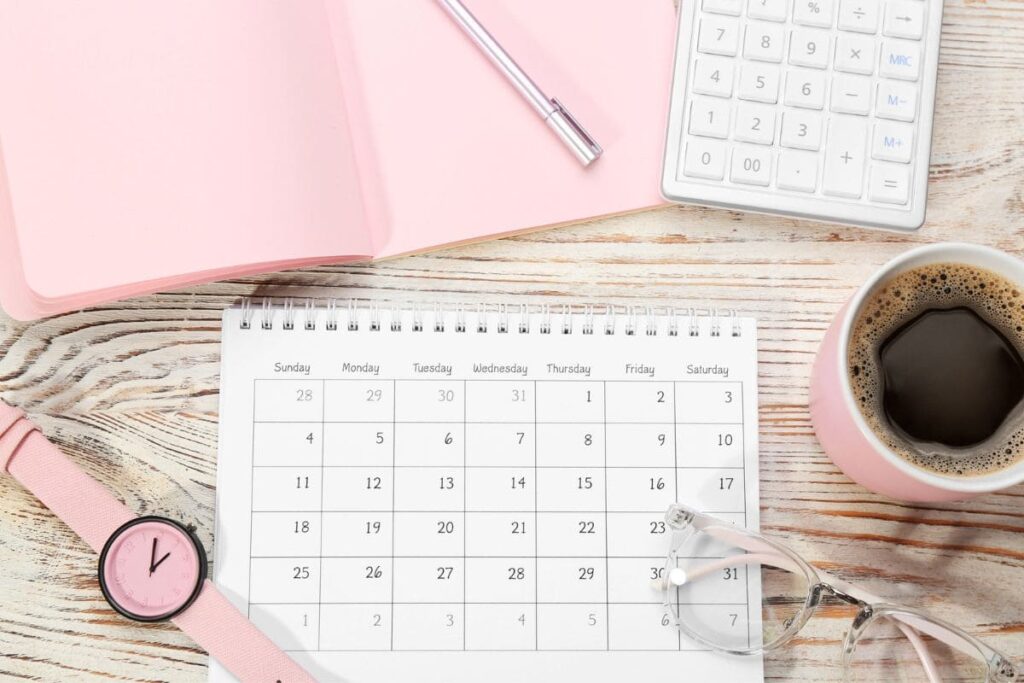 A woman's home office desk, with a calendar and calculator.