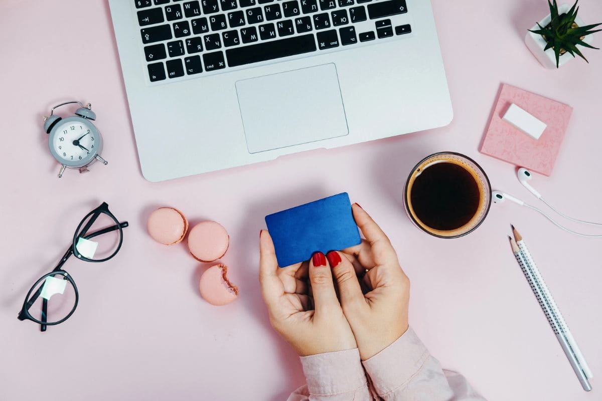 A woman holding a free Walmart giftcard while sitting at a desk.
