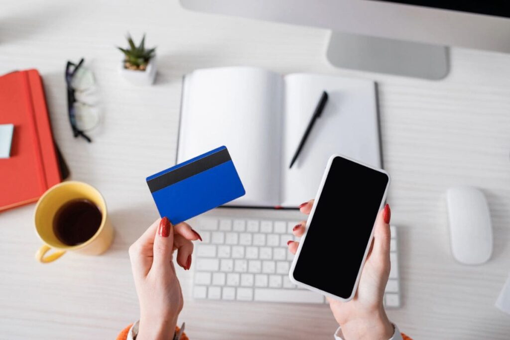 A woman holding a free Walmart giftcard while sitting at a desk.