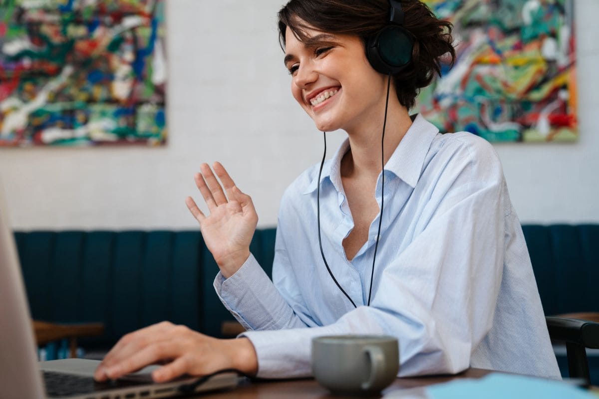 A woman working remotely from home, using a laptop to take video calls for blog post improve your communication skills.
